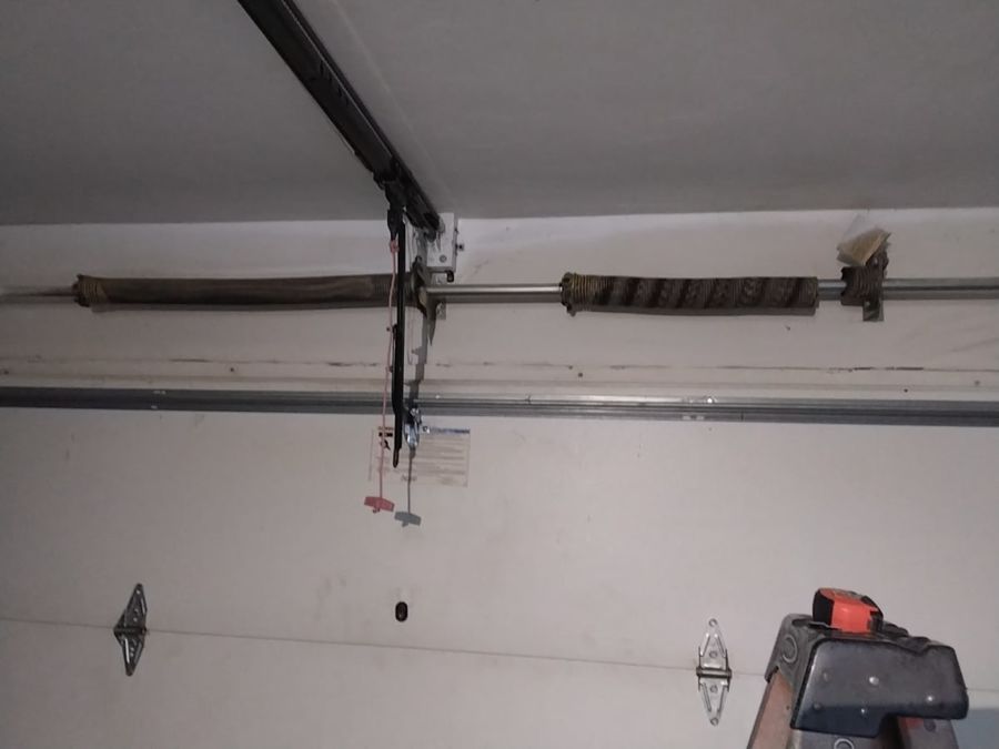 Garage door spring broken on one side in Virginia Beach: two rusted torsion springs on the shaft above the door on the June 2026 visit