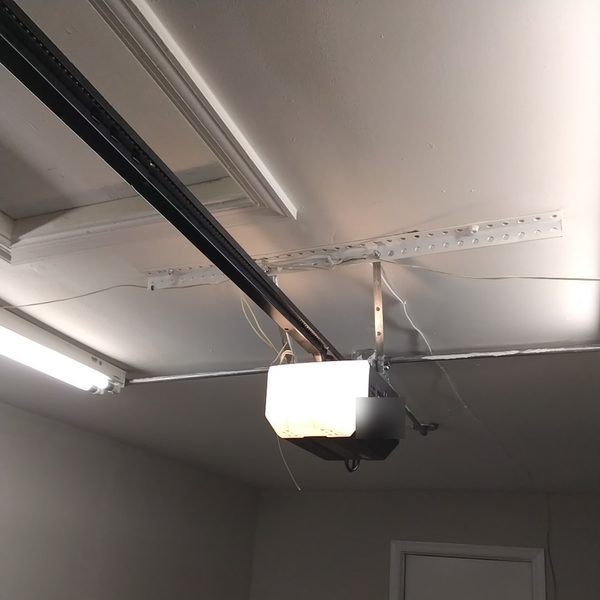 New garage door opener installed on its rail in a Virginia Beach garage after the old opener motor failed